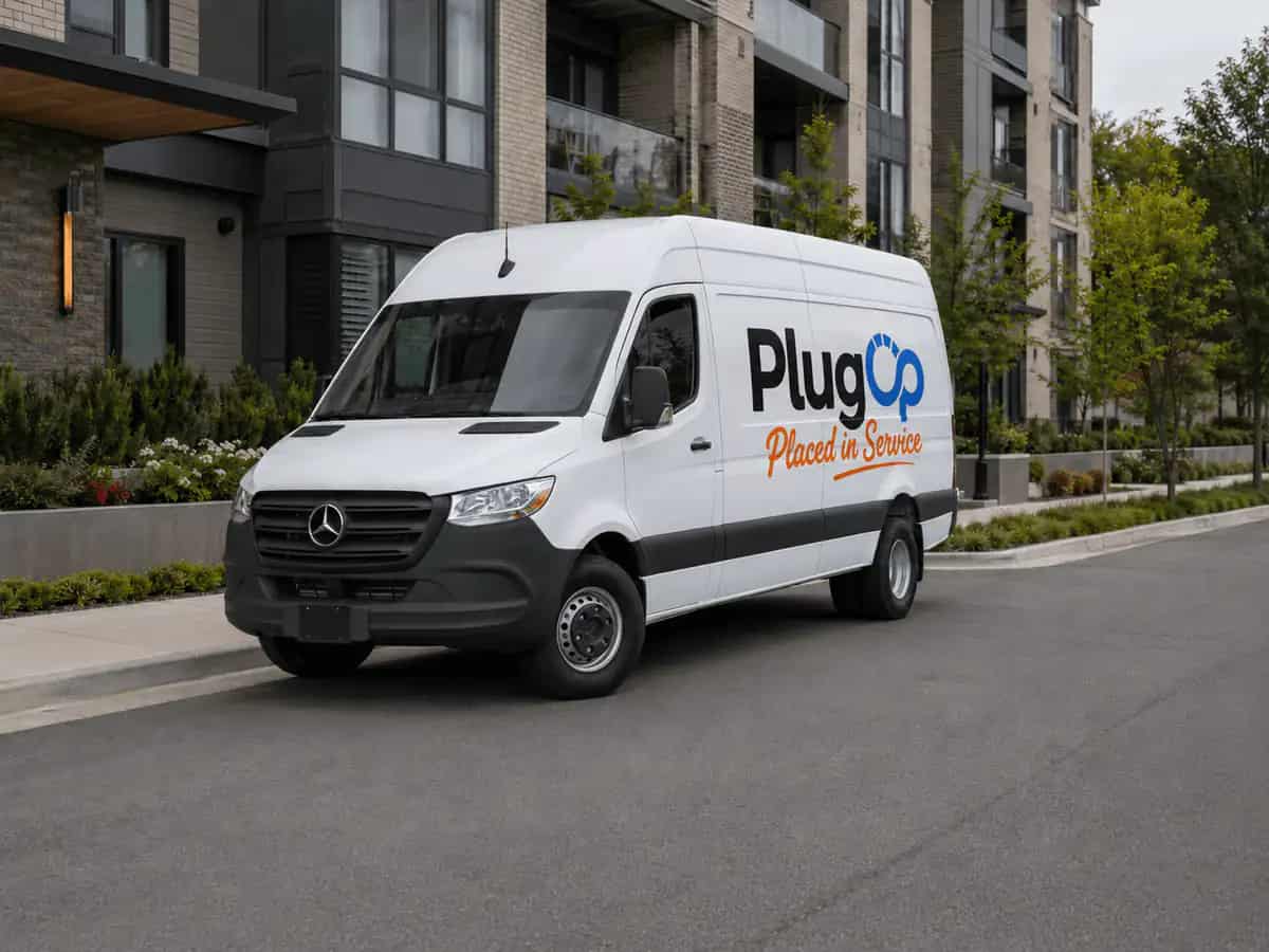 PlugOp service van parked outside a multifamily community