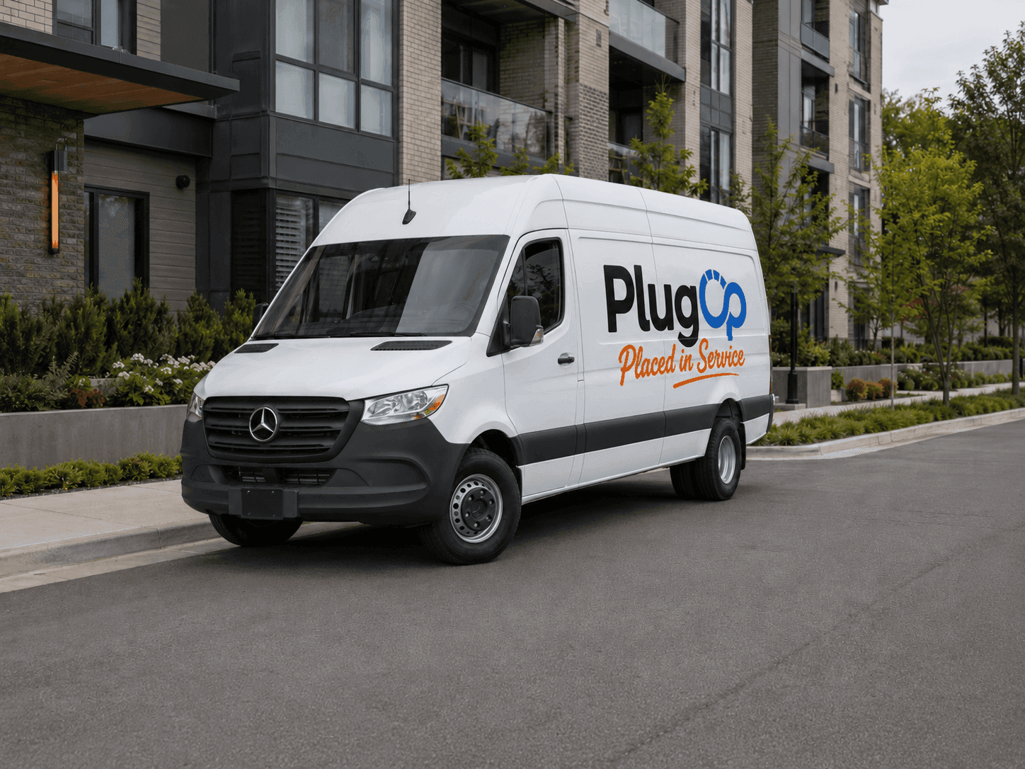 PlugOp service van parked outside a multifamily community